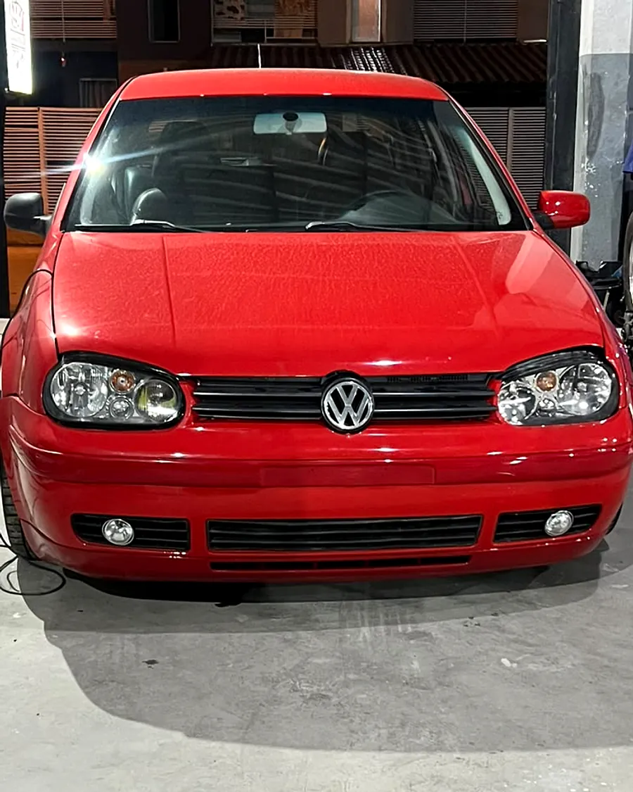 Depois: Golf vermelho com a frente refeita, capô, faróis e para-choque novos