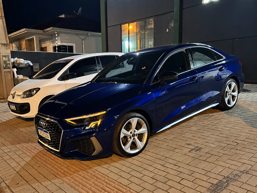 Audi A3 sedan azul na frente da oficina, à noite